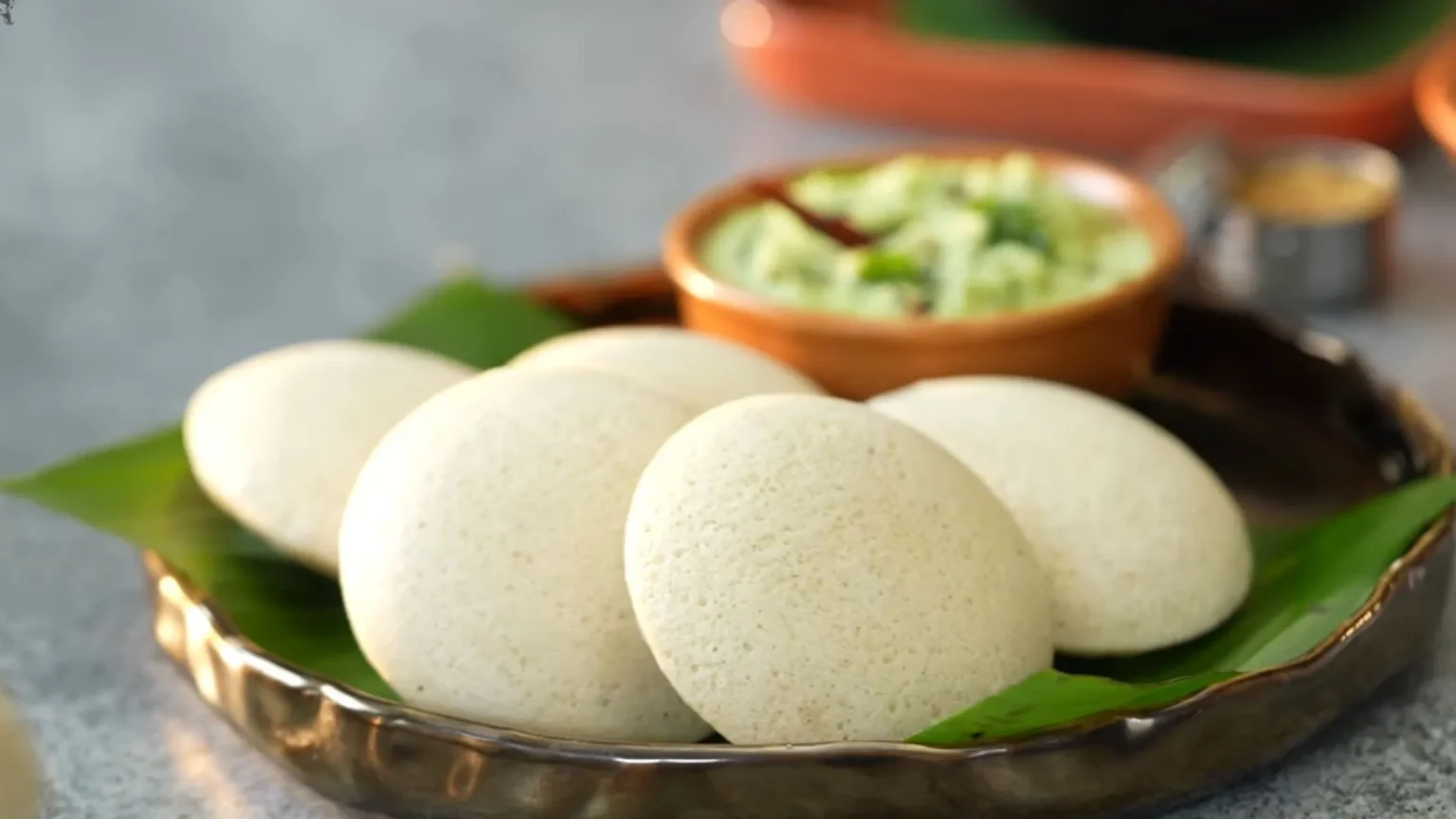 Google Doodle celebrating Idli with chutney, vada, and sambar on a banana leaf