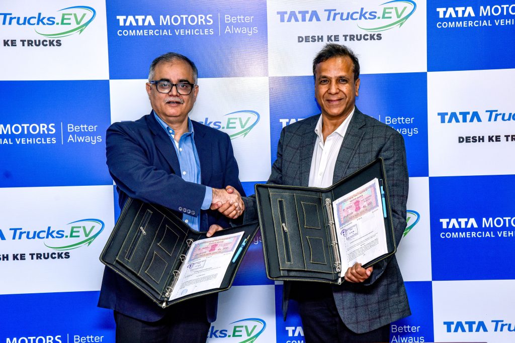 Drivn and Tata Motors officials shake hands after signing the MoU
